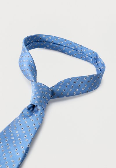 Μπλε μεταξωτή γραβάτα με μικρά λευκά και ναυτικά μοτίβα σε σχήμα σταγόνας, χαλαρά δεμένη και απλωμένη σε λευκή επιφάνεια.