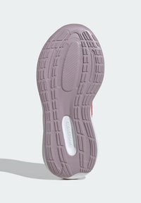 Podeszwa buta z teksturowanym wzorem; głównie fioletowa guma z białymi akcentami i rowkami dla lepszej przyczepności. Z napisem „CLOUDFOAM”.
