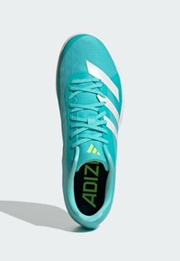 Turquoise athletic shoe with textile upper, three white stripes, textured finish, and black insole featuring yellow branding detail.