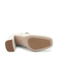 Chaussure à talon beige avec un bout carré, semelle texturée et accents en métal doré. Dispose d'un talon bloc stable et d'une insignia de marque.