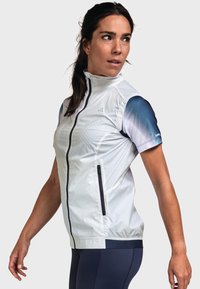 Veste de sport légère et blanche avec un col haut, fermeture éclair sur le devant et des manches dégradées bleues. Elle possède des poches latérales zippées et une texture subtile.