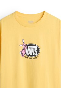 Gelbes Baumwoll-T-Shirt mit einem schwarzen und rosa Grafik eines Kaninchens neben dem "VANS OFF THE WALL"-Logo. Rundhalsausschnitt, lockere Passform.