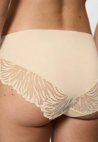 Beżowe majtki o wysokim stanie z koronkową nakładką z wzorem liści wzdłuż dołu. Miękka tkanina o gładkiej fakturze i falbaniastych brzegach.