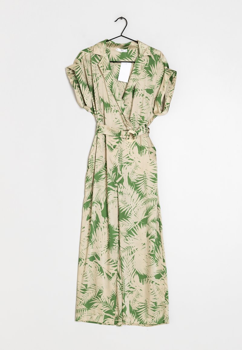 Robe portefeuille longue imprimée de feuilles tropicales beige et vertes, manches courtes et ceinture en tissu, suspendue sur un cintre noir sur fond blanc.