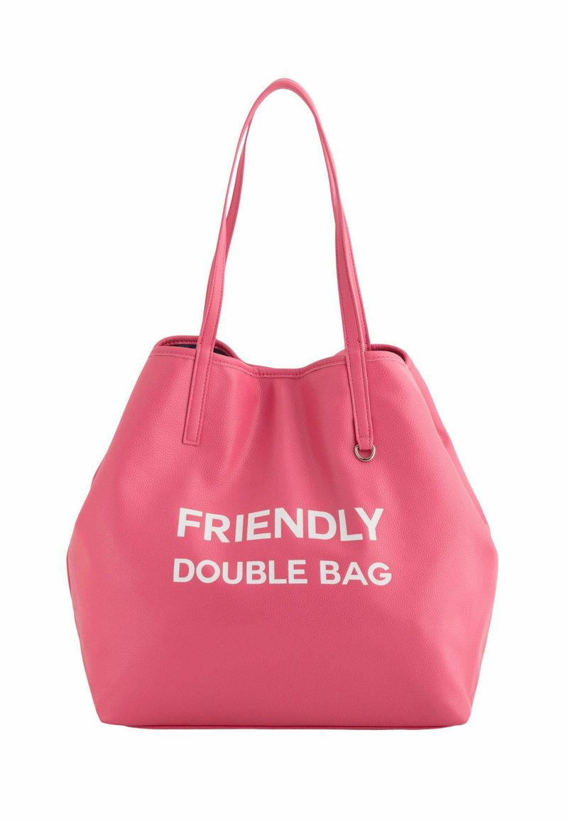 Sac fourre-tout rose en matériau texturé. Dispose de deux longues poignées et d'un texte blanc indiquant "SAC DOUBLE AMICAL" à l'avant.