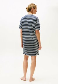 Pasiasta nocna koszula z granatowo-białymi poziomymi paskami, krótkimi rękawami, luźnym krojem i okrągłym dekoltem, wykonana z miękkiego materiału.