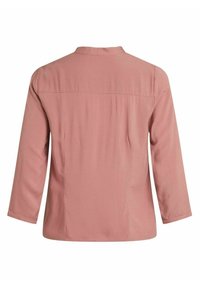 Blusa lunga a maniche con taglio dritto in un delicato rosa, dotata di una cucitura a yoke sulla parte superiore della schiena e una leggera arricciatura sotto di essa.