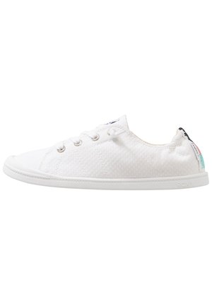 White canvas sneakers with a textured surface, round toe, lace-up front, and a rubber sole. Features logo accents on the heel.