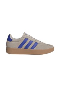 Sneakers in suede beige con tre strisce blu, punta arrotondata e suola in gomma color beige. Presentano una chiusura con lacci e un colletto imbottito.