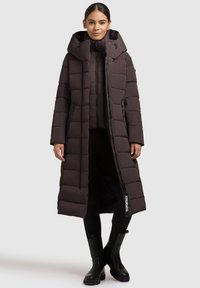 Długa brązowa puchowa kurtka z kapturem, z frontowym zamkiem błyskawicznym, dużymi pikowanymi panelami, dwoma bocznymi kieszeniami i metką z logo na dole.
