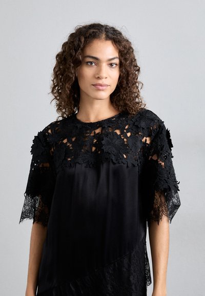 Μαύρο φόρεμα με λουλουδάτο δαντελένιο ντεκολτέ και στα μανίκια. Λείος σατέν κορμός με λεπτομέρεια σε στρώσεις δαντέλας στο στρίφωμα.