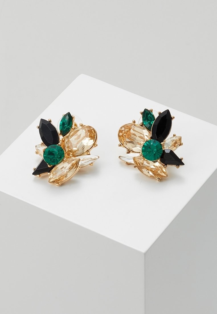 Paire de boucles d’oreilles dorées ornées de pierres précieuses facettées vertes, noires et couleur champagne, disposées en motif floral sur une surface blanche.