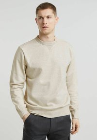 Sweatshirt beige con scollatura a girocollo, maniche lunghe e tessuto testurizzato. Presenta polsini a coste e un logo discreto sul petto.