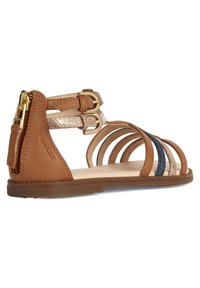 Braune Leder-Sandale mit mehreren Riemen, einschließlich metallic Akzenten. Verfügt über eine flache Sohle und einen doppelt gearbeiteten Schnallenverschluss am Knöchel.
