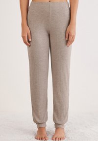 Helle graue, weiche Jogginghosen mit einem elastischen Bund und cuffs an den Knöcheln, entworfen für Komfort. Keine Taschen oder sichtbaren Muster.