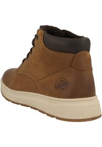 Braune Leder-Stiefelette mit strukturiertem Finish, runder Zehenform, schwarzen Akzenten am Schaft und einem Logo-Patch an der Seite. Gummisohle.