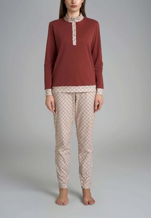 Top a maniche lunghe color ruggine con colletto fantasia; pantaloni beige abbinati con motivo a rombi e design aderente. Tessuto morbido.