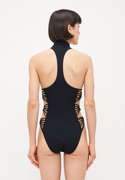 Black one-piece swimsuit with a high collar, open back, and crisscross side detailing secured by small metal accents.