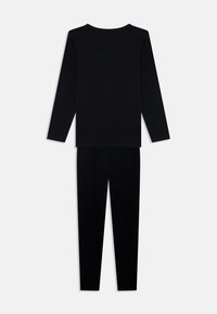 Čierny set s dlhým rukávom a legínami, vyrobený z mäkkej, hladkej tkaniny s priliehavým strihom. Minimalistický dizajn bez vzorov alebo akcentov.
