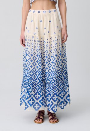 Gonna lunga a strati in crema con motivi geometrici e floreali blu, dotata di una vita elastica e di una silhouette rilassata.