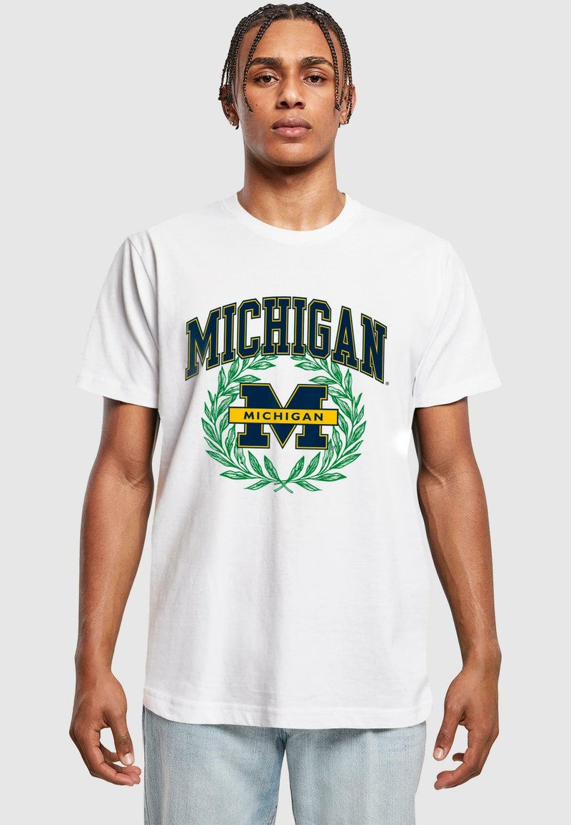 Bílý bavlněný tričko s potiskem "MICHIGAN" a grafikou "M" v modré a žluté barvě, obklopené zeleným vavřínovým designem, krátké rukávy a kruhový výstřih.