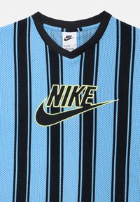 Μπλε και μαύρη ριγωτή αθλητική φανέλα από δίχτυ Nike με V-λαιμόκοψη και κίτρινο λογότυπο, που διαθέτει αεριζόμενη υφή και πλεκτές λεπτομέρειες.