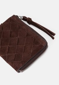 Beige suede piniginė su siuvinėtu raštu, užtrauktuku su sidabro detalėmis ir odine kutu.