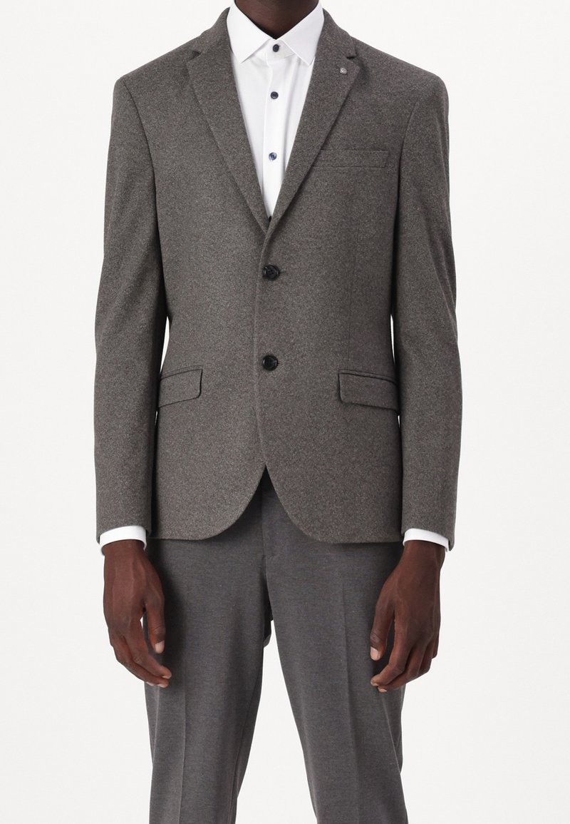 Grå texturerad kavaj med tvåknappsstängning, slagkrage och dubbla framfickor, ihopparad med en vit skjorta med krage och grå byxor.