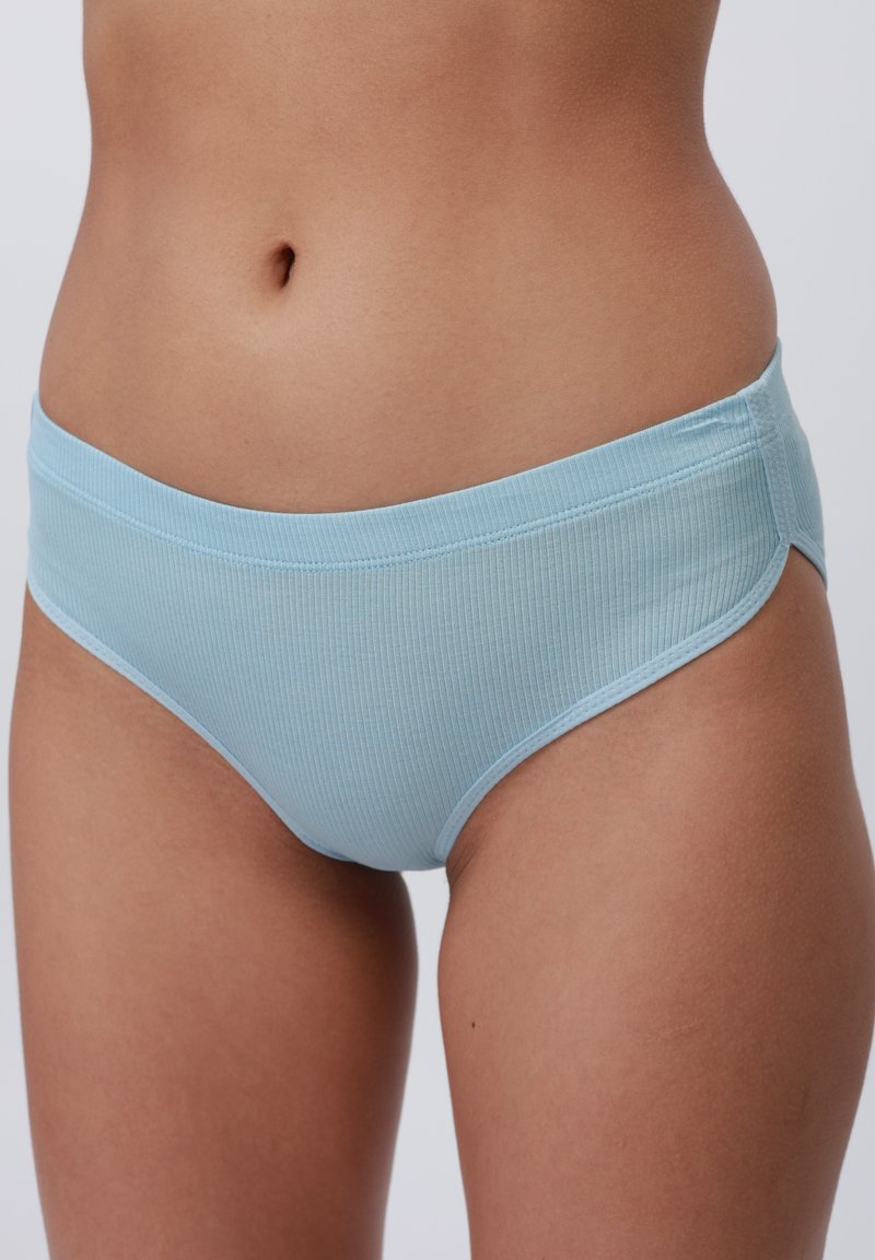 Bas de bikini côtelé bleu clair avec une taille lisse et des découpes sur les côtés, présentant une texture douce et un design discret.