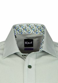 Camicia a quadri verdi con colletto interno a motivi floreali. Presenta un bottone verde e un'etichetta logo nera. Design a vestibilità regolare.