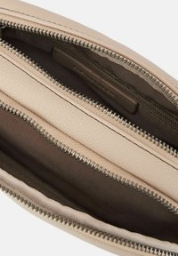 Borsa in pelle crema con tre scomparti con zip. Esterno testurizzato, foderato in modo liscio e cerniere in metallo che accentuano il design.