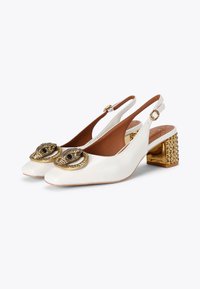 Białe skórzane buty slingback z kwadratowym czubkiem, ozdobione złotym wzorem węża i akcentowanym obcasem w kształcie bloku z cyrkoniami.