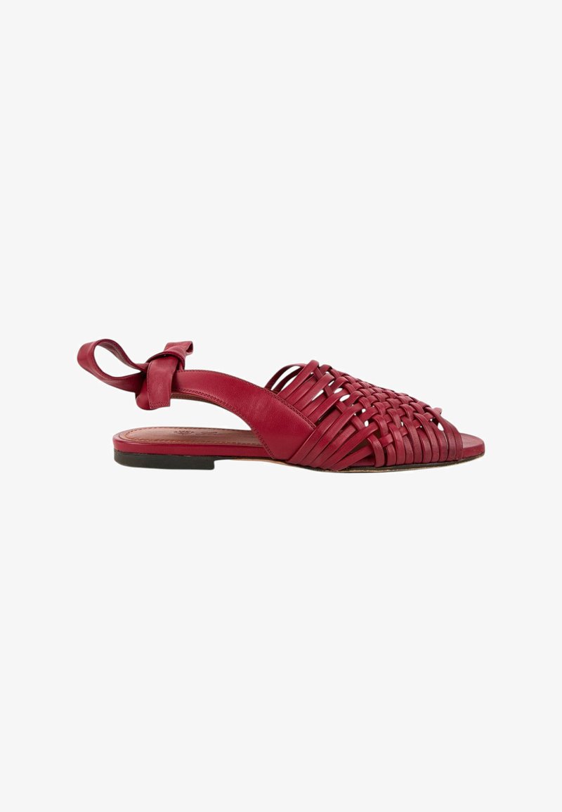 Sandale plate en cuir rouge avec brides tissées à l'avant, bout ouvert, design slingback et fermeture à nouer à la cheville, présentée sur fond blanc.