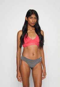 Ροζ σουτιέν με ντεκολτέ σε σχήμα V και ριγέ λεπτομέρειες, συνδυασμένο με γκρι, χαμηλόμεσο, άνετο εσώρουχο χωρίς ραφές. Μαλακό ύφασμα και εφαρμοστή γραμμή.