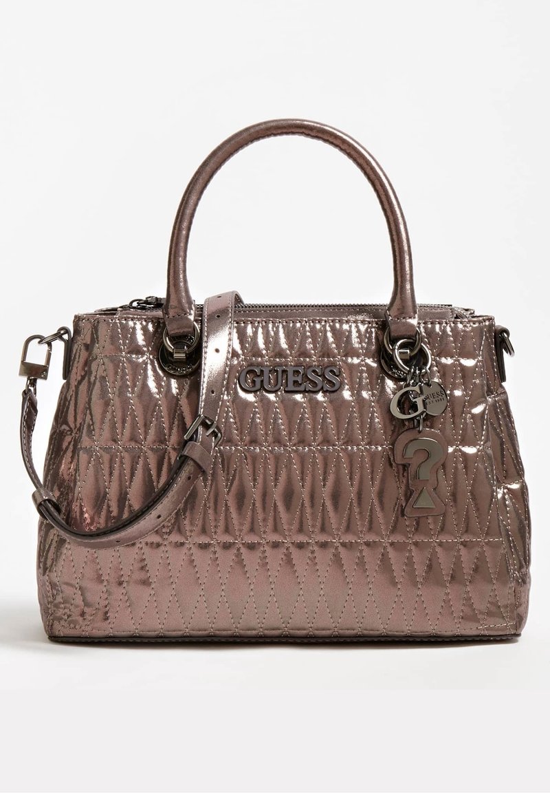 Koonattu metalli kottu vaalean kullanvärisenä, jossa on kaksinkertaiset kahvat ja irrotettava olkahihna. Varustettu vetoketjuisella yläosalla ja logo-yksityiskohdilla.