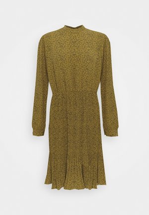 Robe jaune moutarde à manches longues avec petits pois noirs, col montant, taille cintrée et ourlet plissé.