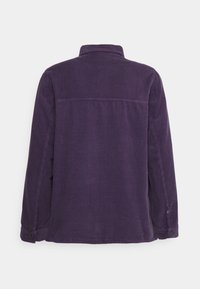 Chaqueta de pana morada con mangas largas, cuello y corte recto. Presenta textura acanalada y puños abotonados. Vista trasera mostrada.