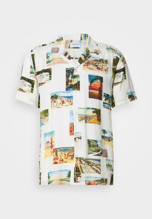 Wit T-shirt met korte mouwen met een collage van tropische landschapfoto's in verschillende kleuren. Lichtgewicht stof, knoopsluiting aan de voorkant en een ontspannen pasvorm.