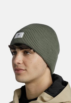 Gorro de punto verde oliva con textura acanalada y una etiqueta de tela blanca con un logotipo. Material suave, diseño ajustado y borde doblado.