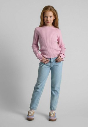 Rosa geripptes Longsleeve-Oberteil mit Rüschensäumen, kombiniert mit hellblauen geraden Jeans und mehrfarbigen Sneakers auf grauem Hintergrund.