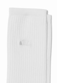 Calze bianche a coste con un sottile design a conchiglia argentata ricamato sul lato. Realizzate in un tessuto morbido ed elastico per garantire comfort.