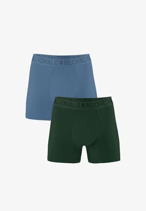 To sæt af boxershorts: et lysblåt og et mørkegrønt. Begge har en kontrastfarvet sort elastik med "MUCHACHO" trykt.