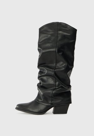 Botas de cuero negro hasta la rodilla con un diseño arrugado, punta afilada y un tacón grueso, con una textura suave y una costura mínima.