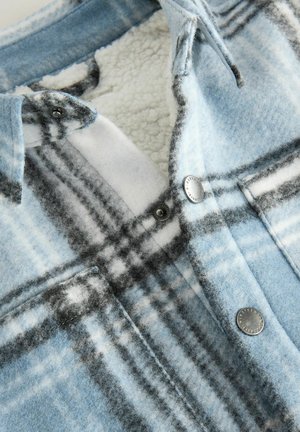 Blau karierte Hemd mit einer weichen, wolleartigen Textur und weißen sowie schwarzen Akzenten. Verfügt über Metall-Druckknöpfe und ein flauschiges Innenfutter.