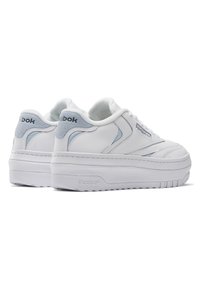 Baskets blanches en cuir avec une semelle compensée, présentant des accents bleu clair et un logo Reebok sur le talon et le côté, texture lisse.