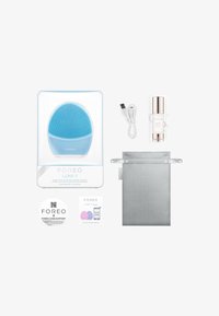 Appareil de nettoyage facial Foreo Luna 3 en bleu clair, avec des poils en silicone, chargeur USB, sérum, pochette de rangement en satin et guide de démarrage rapide.