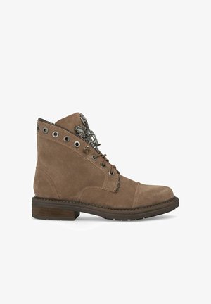 Bottillon en suède beige avec un bout rond, des œillets en métal, une fermeture éclair décorative et un talon empilé. Présente un dessus texturé et des accessoires uniques.