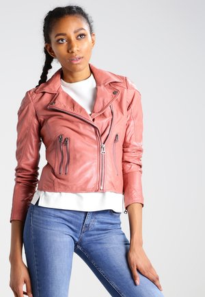 Roze leren motorjack met een slim fit ontwerp, asymmetrische rits en meerdere ritszakken. Draagt over een witte top en jeans.