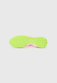 Bright pink soccer shoe sole featuring a textured, neon green rubber outsole with multidirectional studs and "PREDATOR" embossed detail.