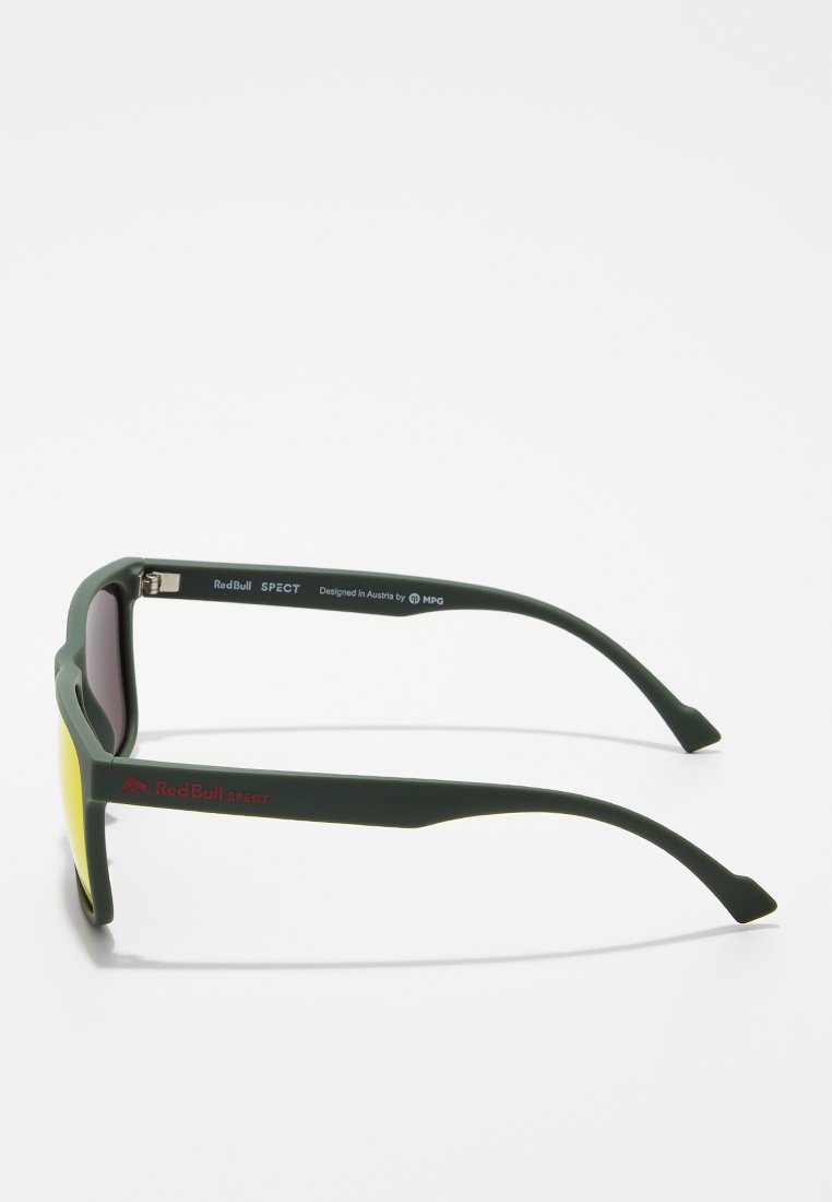 Zielone plastikowe okulary przeciwsłoneczne z żółtymi szkłami. Cechy obejmują prosty kształt, logo na zauszniku oraz bezpieczny mechanizm zawiasu.